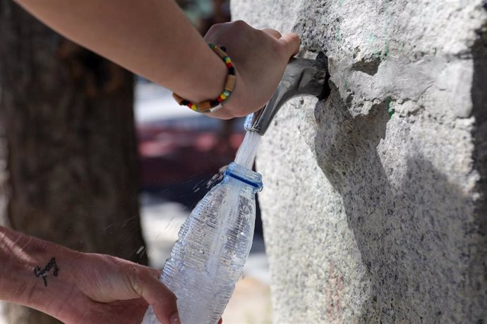 Un joven llena una botella de agua para refresercarse de las altas temperaturas un día antes de que, según la Agencia Estatal de Meteorología (AEMET), llegue a la península Ibérica y a las Islas Baleares la primera ola de calor del verano 2019.