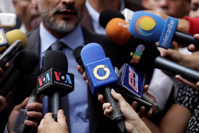 The logo of Globovision TV channel is seen on a microphone used by a TV journalist among other microphones during a news conference in Caracas
