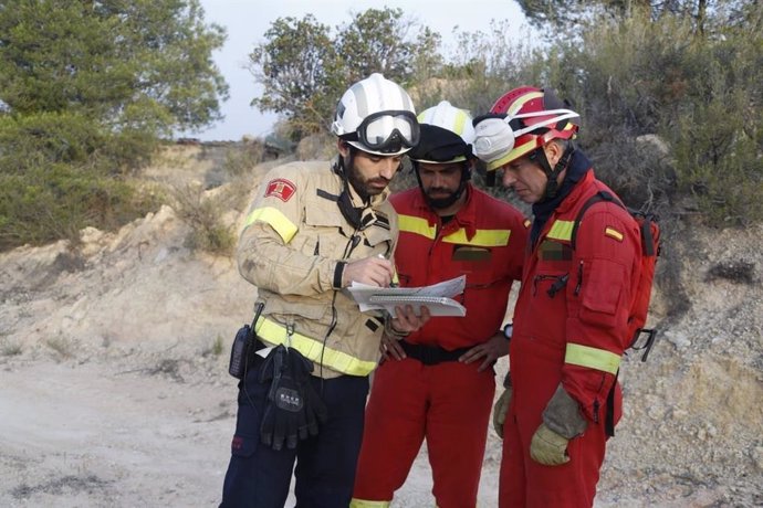 Bombero de la Generalitat y efectivos de la Unidad Militar de Emergencias (UME) durante las labores de extinción del incendio declarado en la comarca de Ribera d'Ebre, en Tarragona