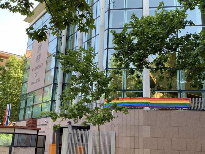 Fachada de la Asamblea de Madrid con la bandera LGTBi para conmemorar la celebración del Orgullo en Madrid.