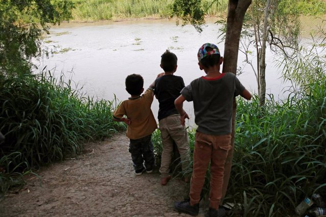 Niños centroamericanos a orillas del río Grande en la frontera entre México y Estados Unidos