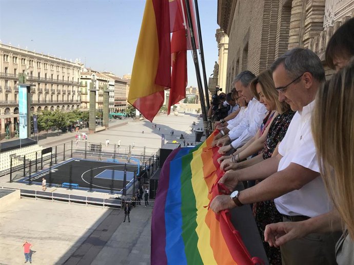 El alcalde de Zaragoza, Jorge Azcón, y concejales de PSOE y Cs despliegan la bandera arcoíris en el Ayuntamiento.