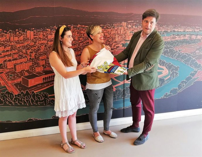 El concejal de Festejos Kilian Cruz entrega una bandera de Logroño a las integrantes de Aires de La Rioja, previo al homenaje a su fundador Javier Santamaría.