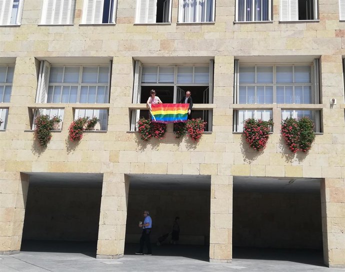 El presidente del pleno, Francisco Javier Pérez, y la concejala de Igualdad, Eva Tobías, cuelgan la bandera LGTBi+ en la fachada del Ayuntamiento de Logroño.