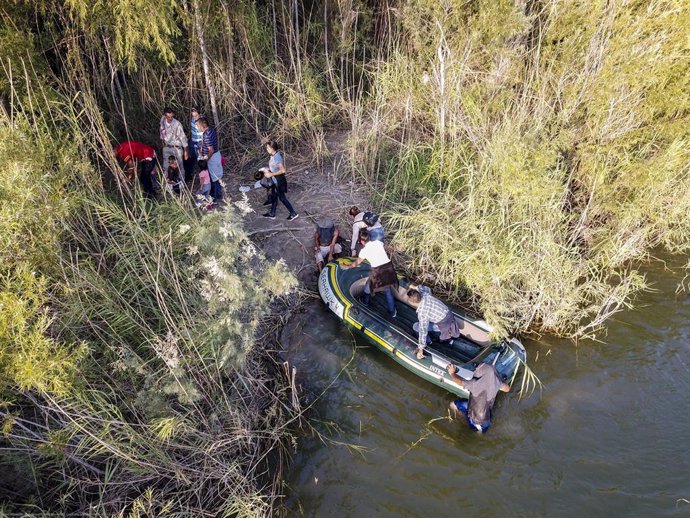 Migrantes cruzando el río Bravo