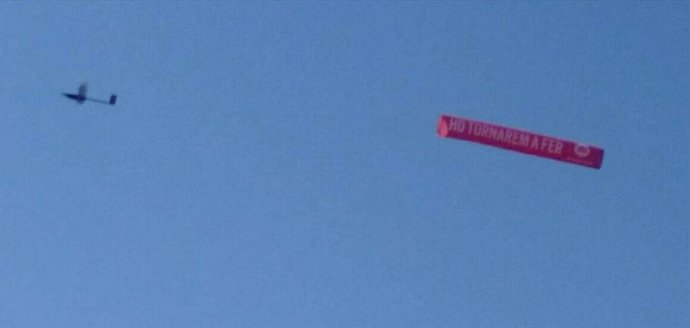 Dron amb pancarta d'mnium Cultural amb el lema 'Ho tornarem a fer'