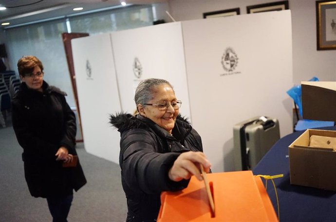 Una mujer deposita su voto en una urna durante las primarias en Montevideo.