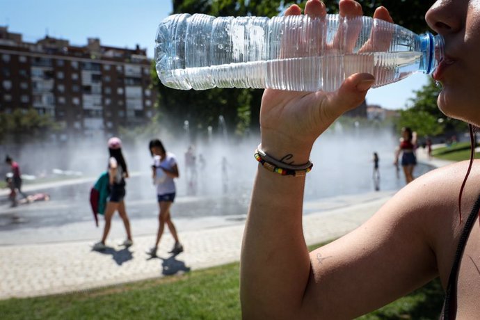 Una dona beu aigua de botella per refrescar-se prop de Madrid Río un dia abans que, segons l' Agncia Estatal de Metereologia (AEMET), arribi a la península Ibrica i a les Balears la primera ona de calor de l'estiu del 2019.