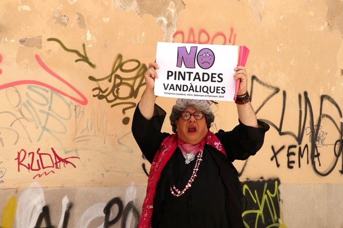 El personaje Mad Pereta, interpretado por Joan Carles Bestard, posa con un cartel en contra de las pintadas vandálicas de la ciudad de Palma