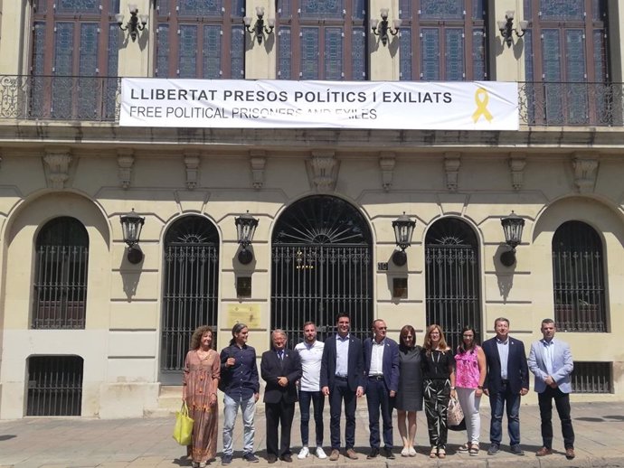 L'alcalde Miquel Pueyo amb part dels regidors de govern d'ERC, el Comú i JxCat sota la pancarta de l'Ajuntament de Lleida