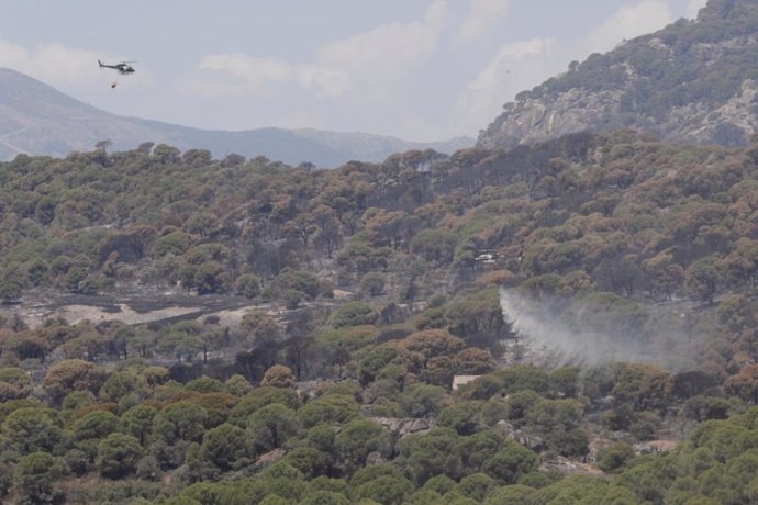 Un helicóptero trabaja en la extinción de un incendio forestal que afecta a las localidades de Cenicientos y Cadalso de los Vídrios.