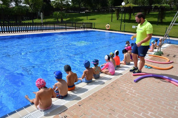 Monitor de natación supervisa su clase de iniciación en Tomares