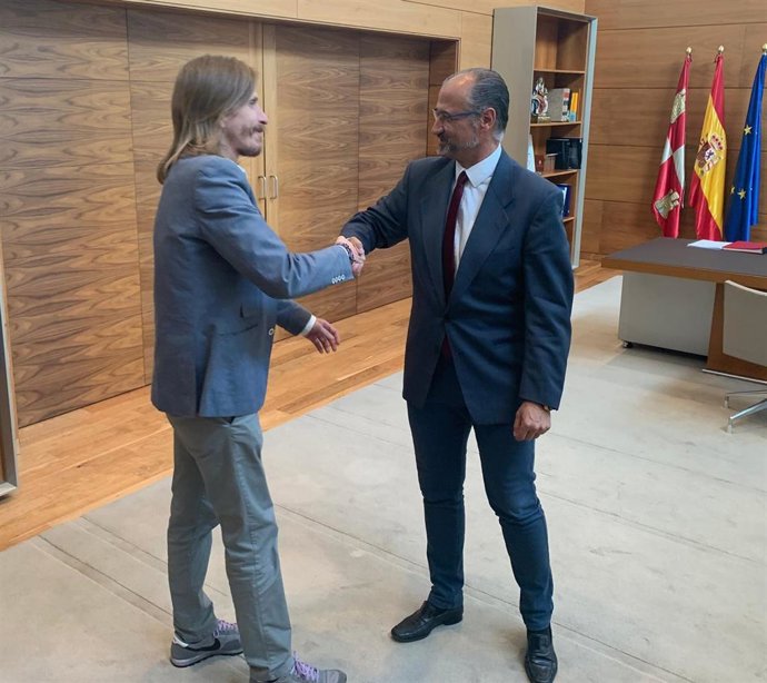 El procurador de Podemos en las Cortes de Castilla y León (izda) y el presidente del Parlamento regional, Luis Fuentes, se saludan antes de la reunión que han mantenido.