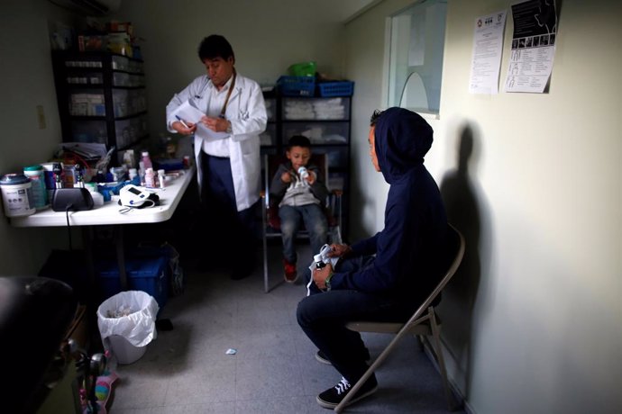 A Central American man and child visit the doctor at the Catholic shelter "San Francisco Javier Church\