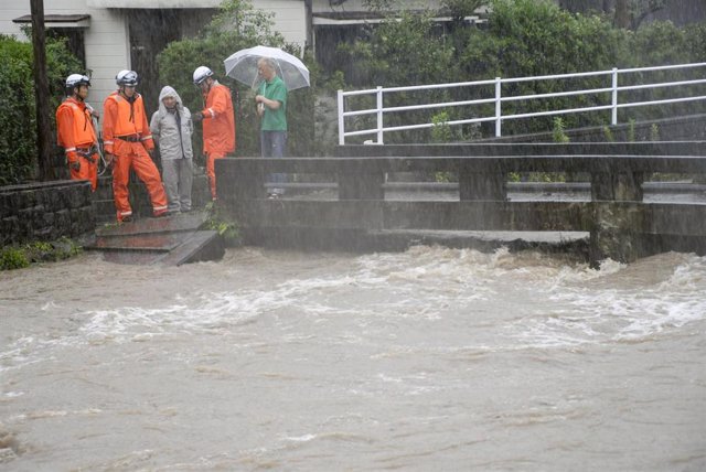 Los equipos de rescate y residentes locales observan el río Wada desbordado debido a las fuertes lluvias en Kagoshima (Japón)