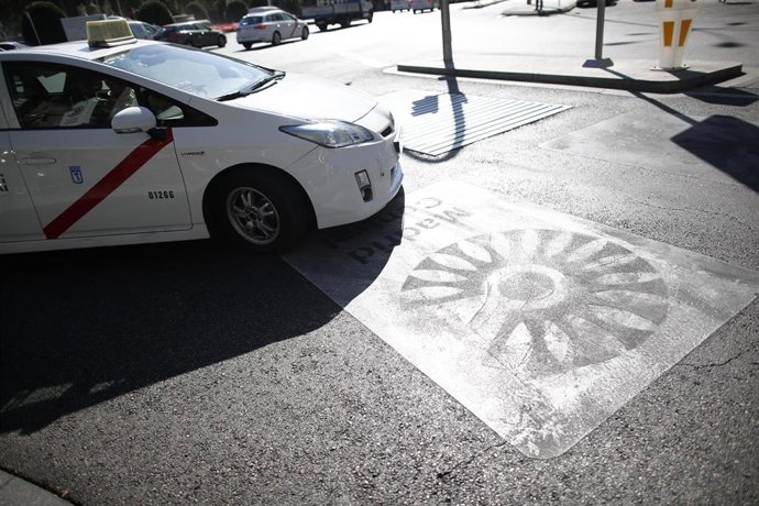 Un taxi pasa por encima de una señal de Madrid Central que indica restricciones al tráfico en el centro de la capital 