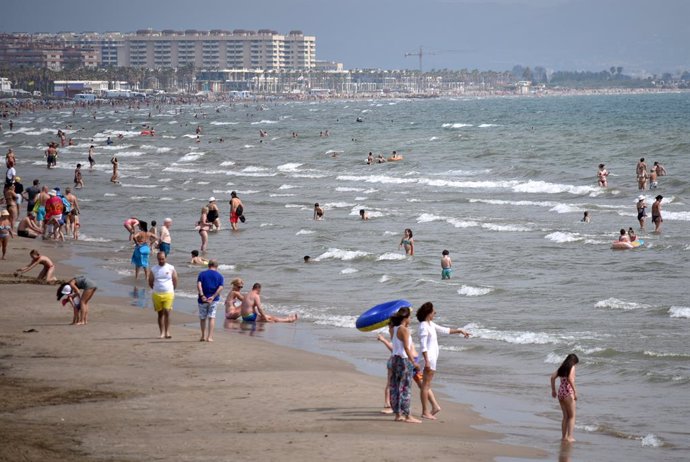 Varias personas se bañan en en mar Mediterráneo en la playa de la Malvarrosa de Valencia en el día del Inicio del verano 2019.