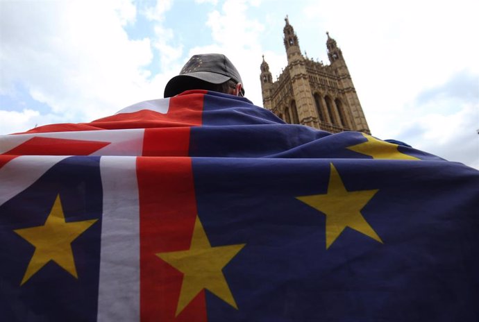 Un activista con una bandera que une las enseñas de la Unión Europea y de Reino Unido, situado ante el palacio de Westminster, en Londres