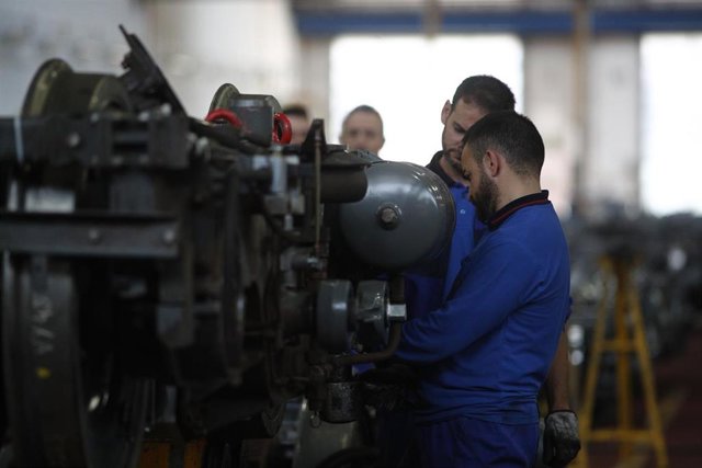 Dos trabajadores del Centro de Control de Metro, trabajando con un motor.