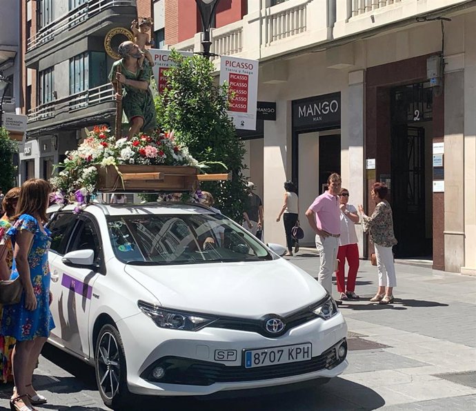 Imagen de San Cristóbal portada por un taxi.