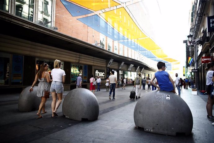 Turistas y vecinos de la zona Centro de Madrid pasean por la calle Preciados bajo la sombra gracias a los toldos instalados.