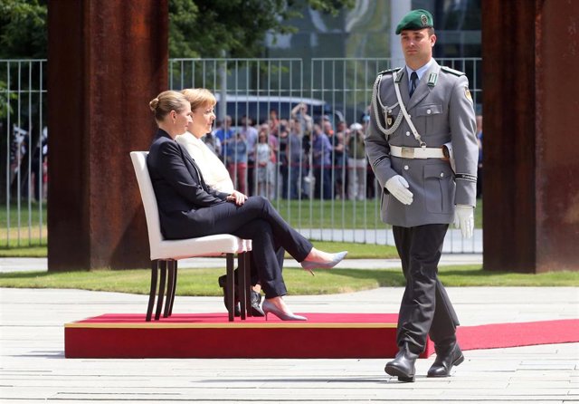 Angela Merkel y la primera ministra danesa, Mette Frederiksen, pasan revista a la guardia de honor