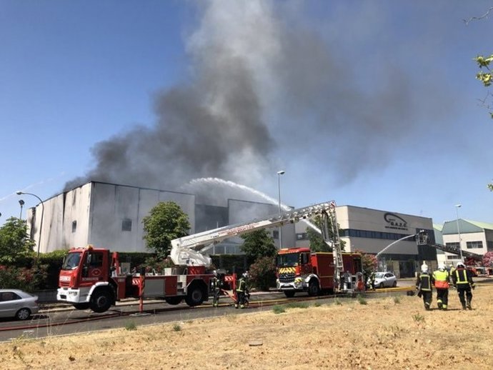 Bomberos tratan de apagar el incendio producido en una fábrica de productos disolventes en la localidad de Fuenlabrada.