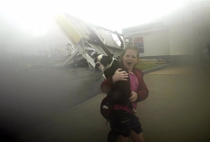 Niña de Nueva Orleans corre de la lluvia con su perro en brazos