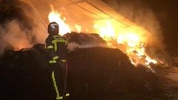 Bomberos de la Comunidad de Madrid trabajan en la extinción de un incendio en una nave de pacas de paja en Villanueva de Perales que ha provocado la muerte de 10 cabras.