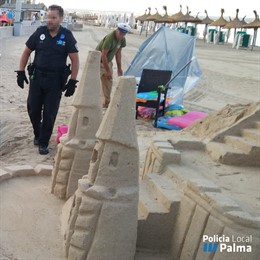 Agents de la Policia Local de Palma, durant l'operatiu en el qual s'han retirat castells de sorra de la platja de Palma.