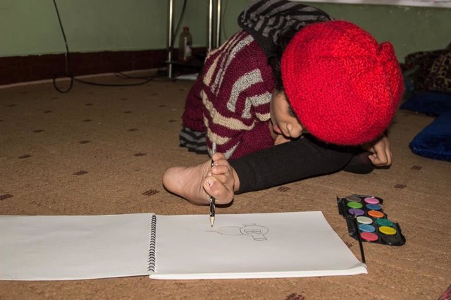 Shaysta, una niña desplazada en Afganistán, dibuja con su pie