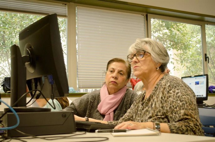 Dos mujeres de la tercera edad mirando la pantalla de un ordenador