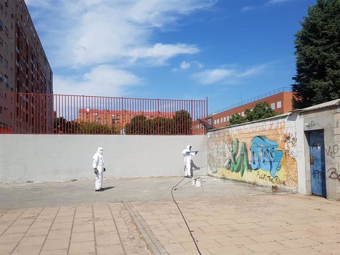 Efectivos de limpieza del Ayuntamiento de Madrid borran una pintada en el distrito de Usera.