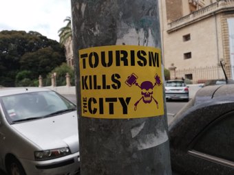 Pegatina con el mensaje 'Tourism kills the city' e