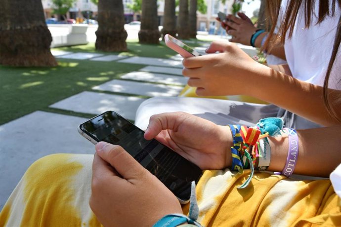 Jóvenes utilizando el movil en un parque de la localidad sevillana.