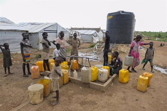 Mujeres y niños en un pozo de agua en un campamento de desplazados de la ONU en la capital de Sudán del Sur, Yuba.