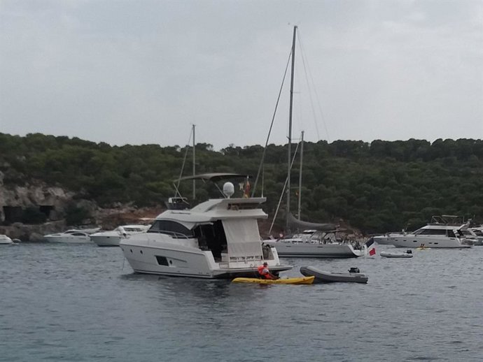Un operario de la Cruz Roja se acerca a una embarcación fondeada en Cala Portals Vells con el objetivo de realizar vigilancia ambiental y concienciar sobre la preservación de la Posidonia Oceánica