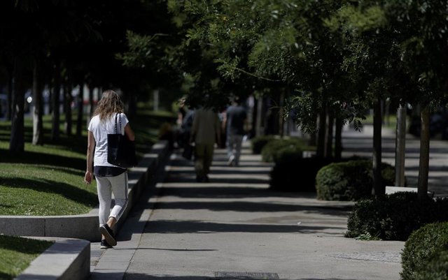 Algunas personas caminando por las calles del Paseo de Recoletos de Madrid en el segundo día de la ola de calor que estará presente posiblemente hasta el 1 de julio.