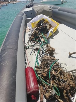 Una embarcación durante las tareas de limpieza de fondos marinos en Ses Figueres
