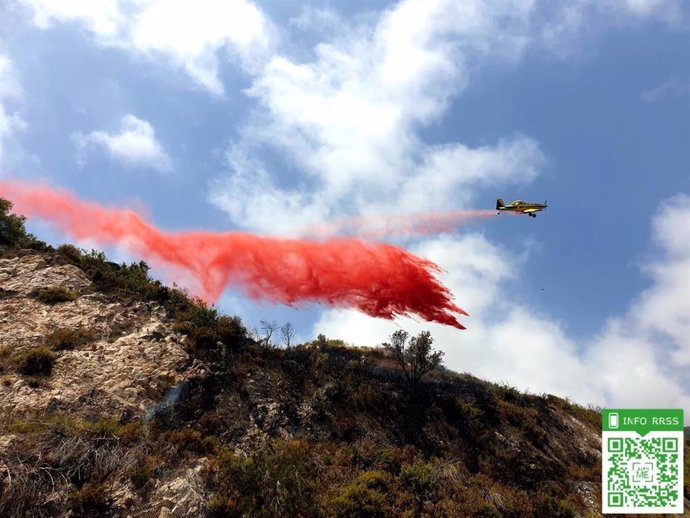 Un avión de Infoca lanza agua sobre un incendio forestal en Ojén