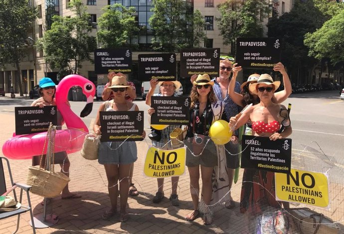 Activistas de Amnistía Internacional protestan ante las oficinas de TripAdvisor en Barcelona para criticar que la plataforma contribuye "a la expansión de los asentamientos ilegales que Israel mantiene" en Palestina