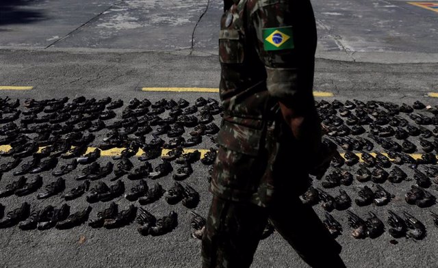 Un soldado brasileño camina junto a las armas incautadas a organizaciones criminales