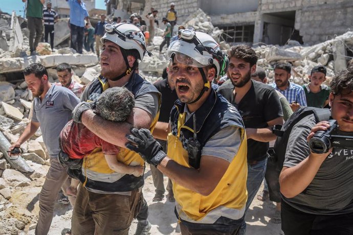 Los 'cascos blancos' rescatan a un niño con vida de los escombros tras el ataque contra un mercado de Maarat al Numan, en Idlib (Siria)