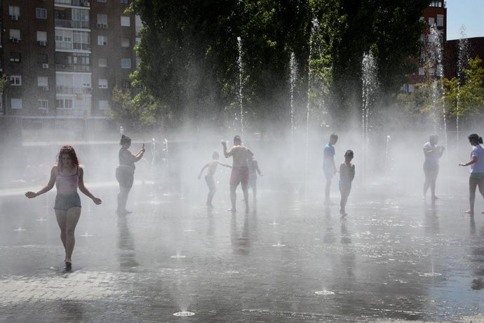 Varias personas, entre ellas niños, se refrescan en los chorros de Madrid Río un día antes de que, según la Agencia Estatal de Meteorología (AEMET), llegue a la península Ibérica y a las Islas Baleares la primera ola de calor del verano 2019.