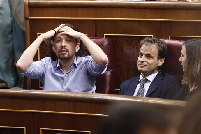 El secretario general de Unidas Podemos, Pablo Iglesias (llevándose las manos a la cabeza); el portavoz de ECP en el Congreso, Jaume Asens; y la portavoz adjunta de Podemos en el Congreso, Ione Belarra, sentados en sus escaños durante la segunda sesión 