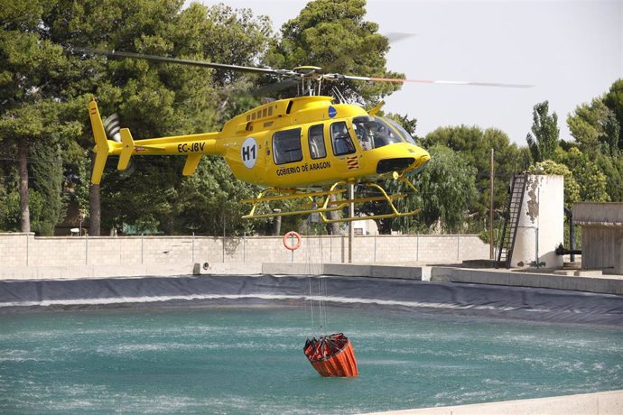 Un helicóptero del operativo de extinción de incendios recoge agua en una balsa habilitada para ello.