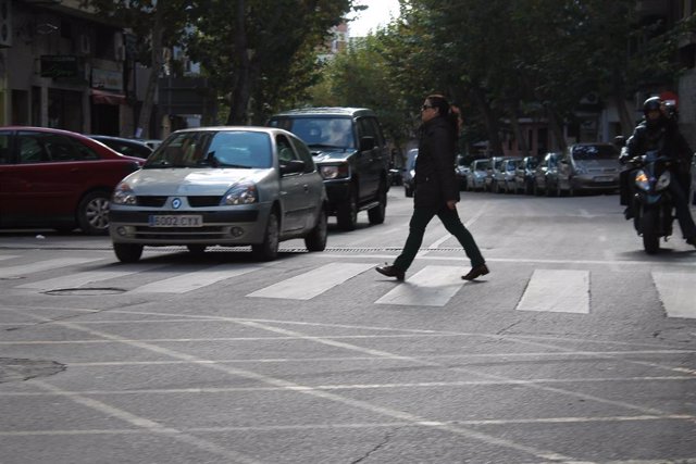 Una mujer cruzando un paso de peatones