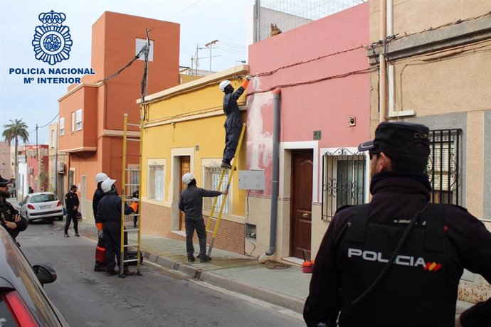 Un técnico de Endesa escoltado por la Policía Nacional procede a desactivar un enganche ilegal de electricidad en Pescadería, en Almería