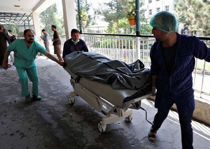 Emergency workers transport the dead body of a victim to the hospital after a blast in Kabul, Afghanistan