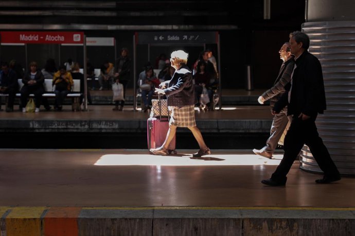 Pasajeros con maletas en los andenes de la Estación de Tren Madrid Puerta de Atocha.  